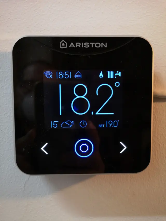 Termostato digital en la pared marcando 18,2 grados