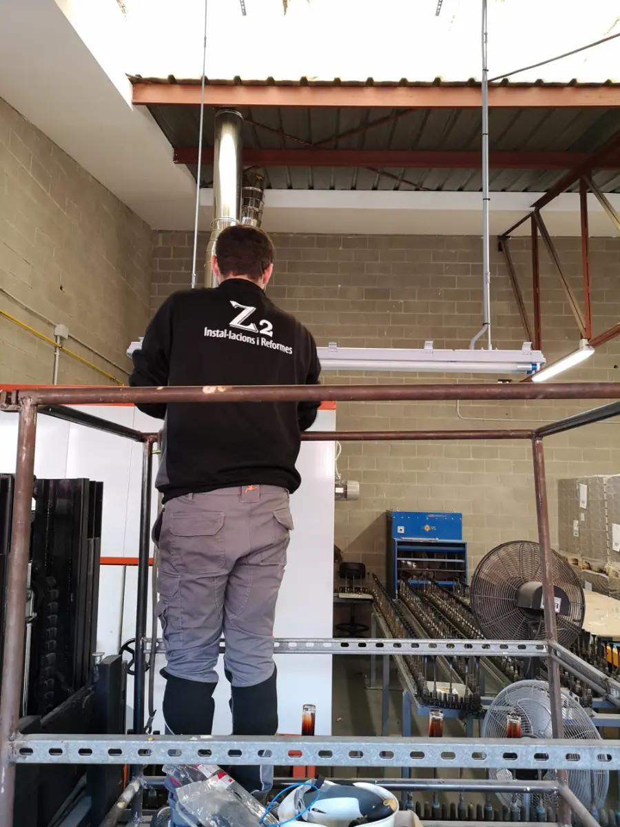 Instalador de Z2, con la sudadera de la empresa, trabajando subido a un andamio